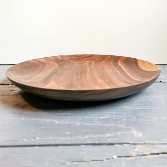 grande assiette en bois foncé artisanale